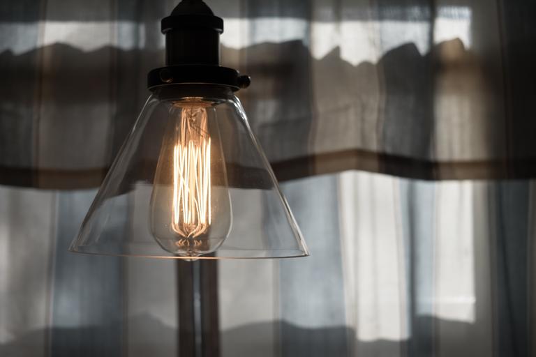 Lampa so skleneným tienidlom a zapálenou žiarovkou